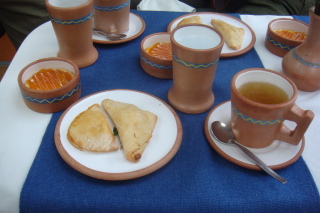 a table with plates of food and cups of tea