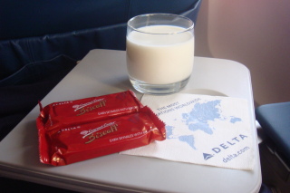 a glass of milk and chocolate bars on a table
