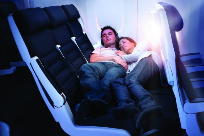 a man and woman sleeping on an airplane