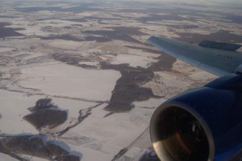 an airplane wing and engine above snow