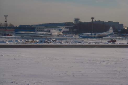 a snowy airport with airplanes