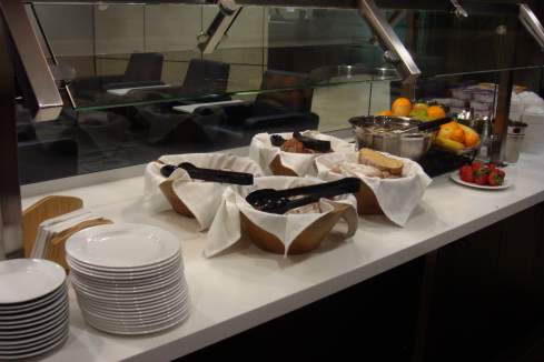 a buffet line with plates and fruit