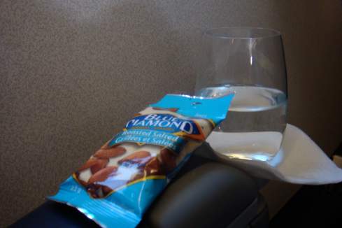 a bag of almonds next to a glass of water