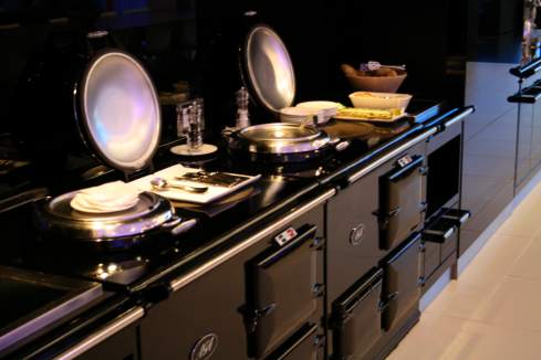 a kitchen with black cabinets and silver dishes
