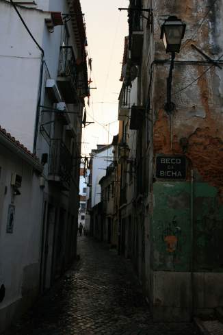 a narrow street with buildings and a person walking