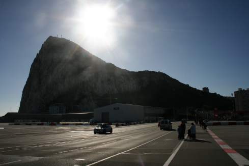 a road with cars and a mountain in the background