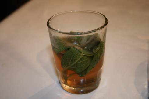 a glass with a drink and leaves