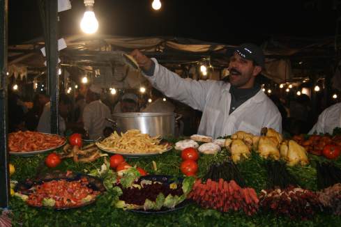 a man standing at a food stall