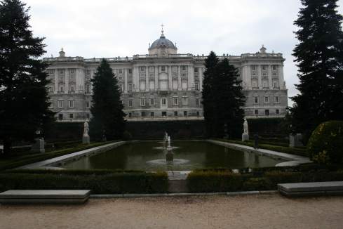 a large building with a fountain in front of it with Royal Palace of Madrid in the background