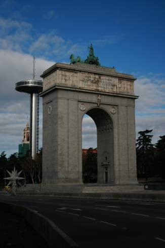 a large stone arch with a statue on top