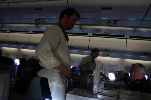 a man serving food on an airplane