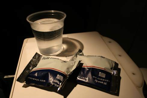 a glass of water and packets of liquid