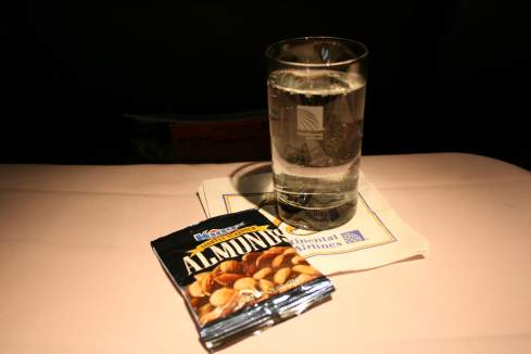 a glass of water and a packet of almonds