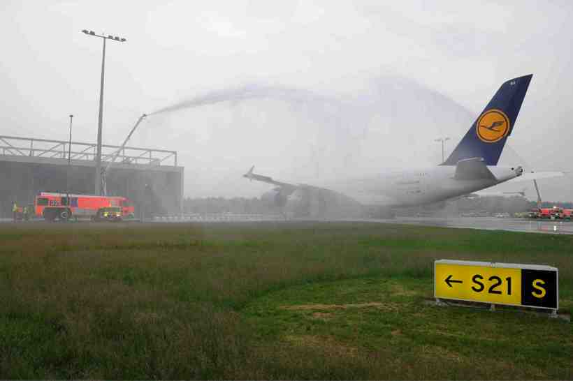 a fire truck spraying water on an airplane