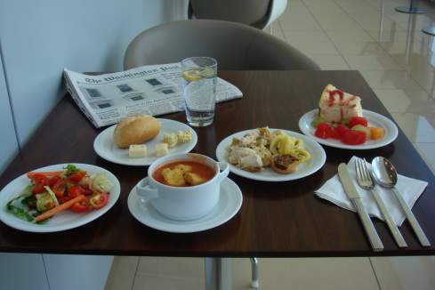 a table with plates of food and a newspaper