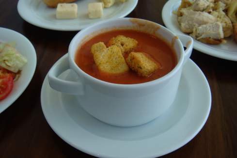 a bowl of soup with croutons on a plate