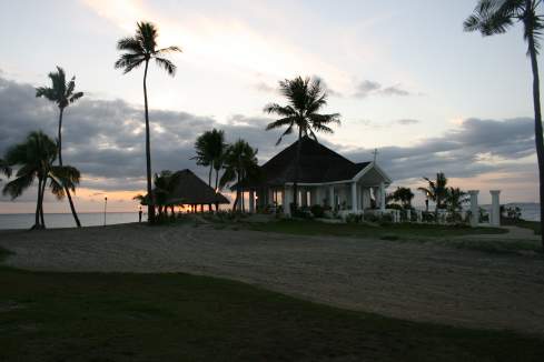 a house with palm trees on the beach