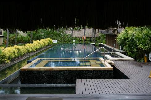 a pool with a railing and a wooden deck