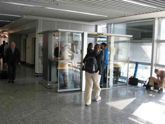people standing in a room with glass booths
