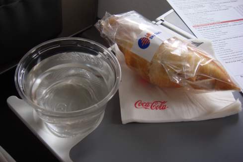 a plastic bag of bread and a glass of water