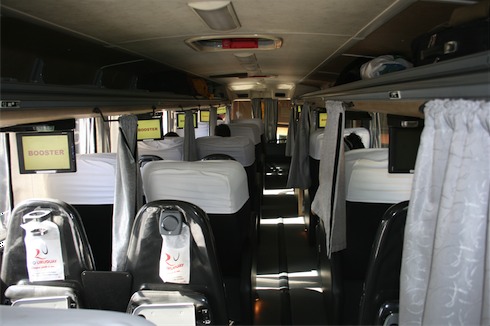 a bus with white seats and white sheets