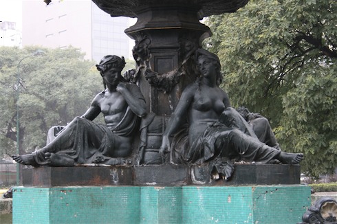 a statue of a woman and a man sitting on a fountain