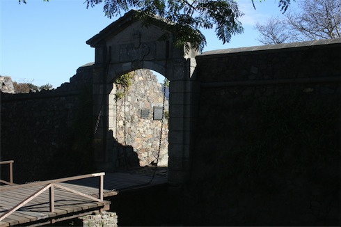 a stone wall with a bridge and a sign