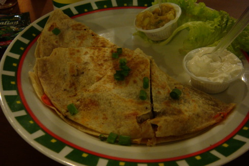 a plate of quesadilla with a side of salad