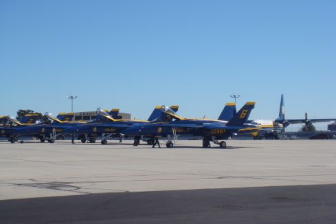 a group of blue jets parked on a tarmac
