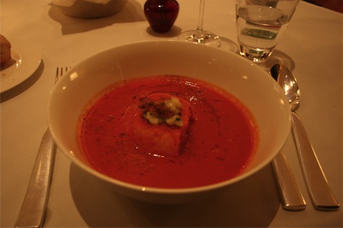 a bowl of soup with a piece of cheese