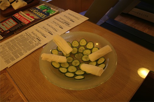 a plate of cucumbers and cheese rolls