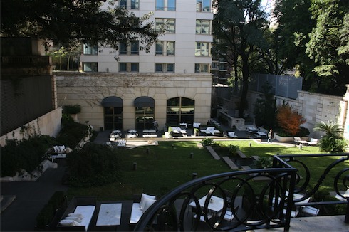 a view of a courtyard with chairs and trees