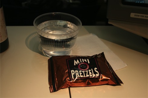 a bag of pretzels and a cup of water
