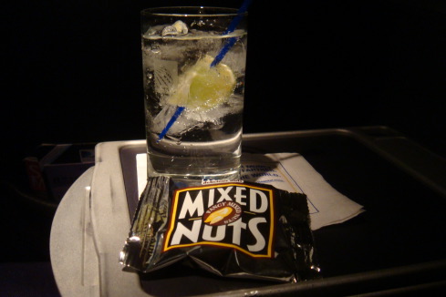 a glass of water with a straw and a bag of nuts