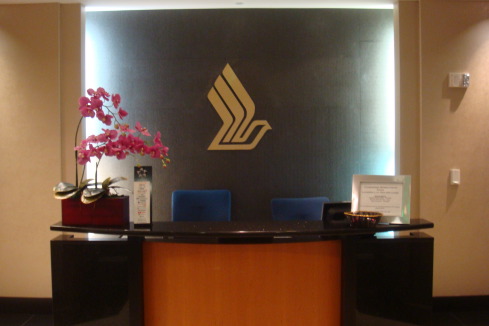 a reception desk with a logo on the wall