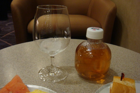 a glass of liquid next to a bottle of liquid