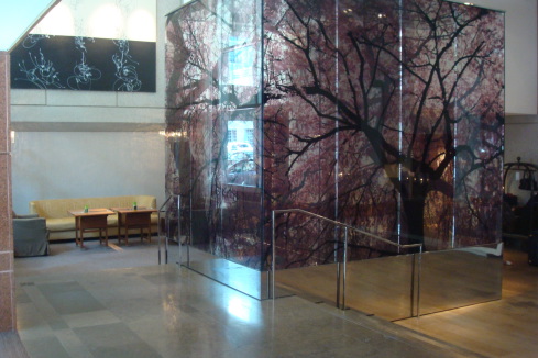 a glass wall with a tree mural