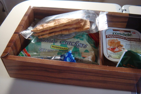 a wooden box with crackers and cheese