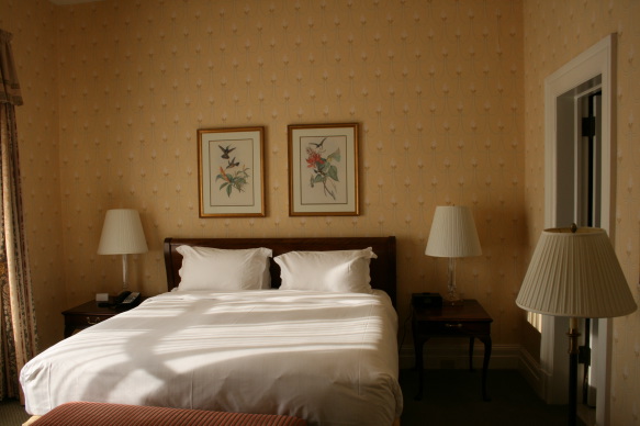 a bed with two lamps and a picture on the wall