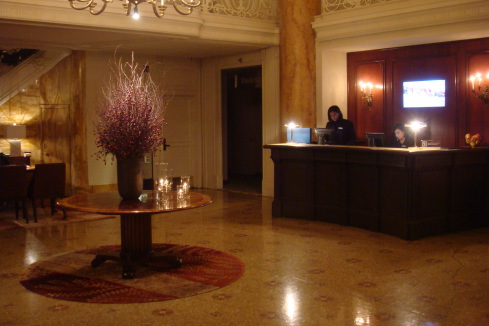 a lobby with a table and a woman behind it