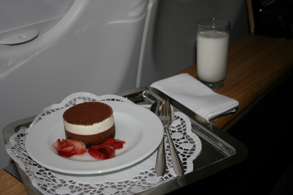 a plate of dessert with strawberries and a glass of milk