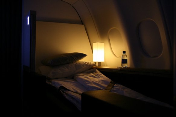 a bed with pillows and a lamp on a table