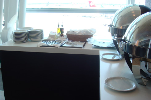 a buffet table with plates and a bowl of food