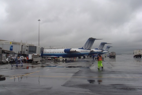 a group of airplanes on a wet runway