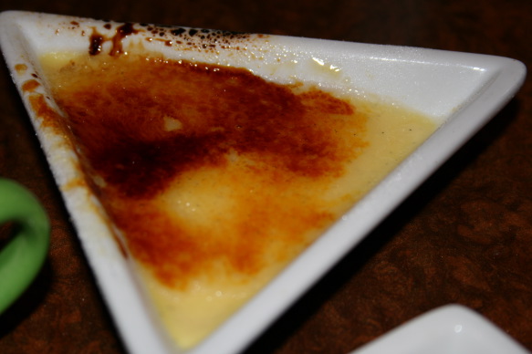 a triangle shaped dish with a brown liquid in it