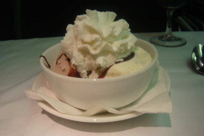 a bowl of ice cream with whipped cream on top