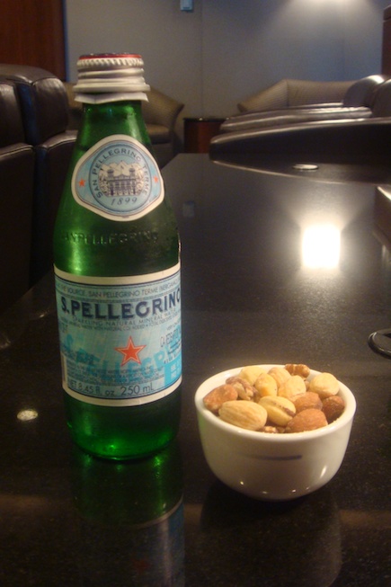 a bowl of nuts and a bottle of beer