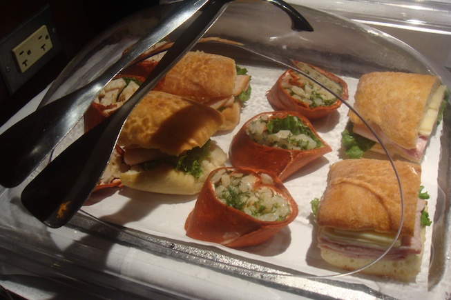 a tray of sandwiches and tongs