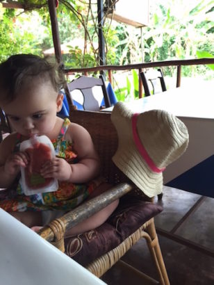 Lucy eating her baby food pouch in Costa Rica