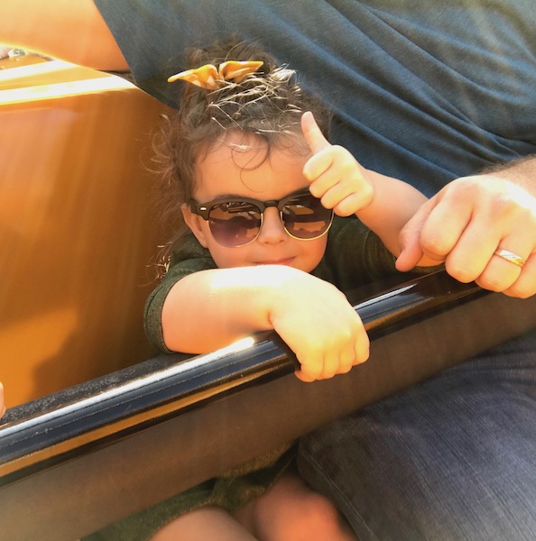 a child wearing sunglasses and holding a handrail